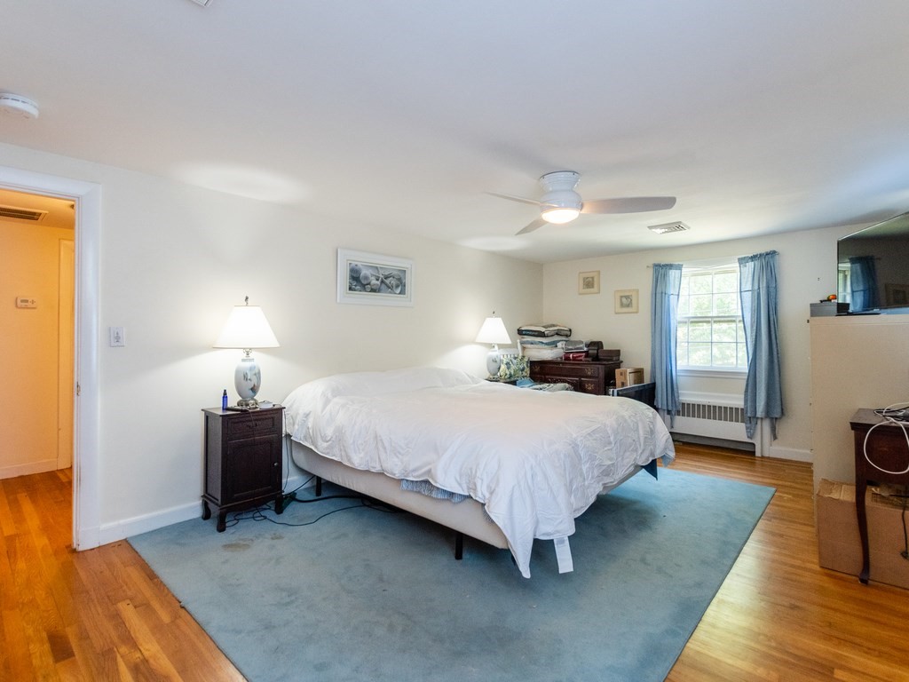 95 Blake Street Newton, MA 02460 - Photo 16 of 22 a spacious bedroom with a bed and a lamp on table and a window