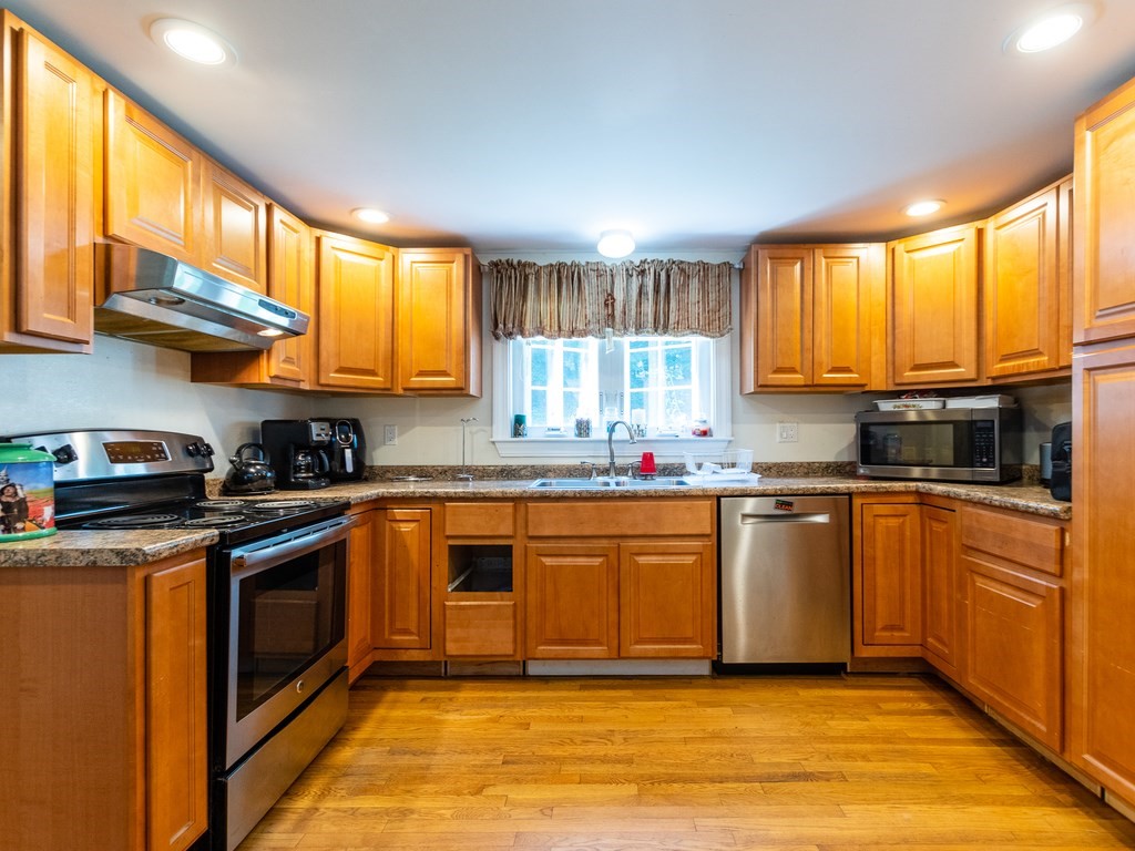 95 Blake Street Newton, MA 02460 - Photo 6 of 22 a kitchen with stainless steel appliances granite countertop a stove a sink and a microwave