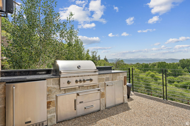 1400 Weber Wild Road Oakley, UT 84055 - Photo 25 of 55 Outdoor kitchen with a stainless steel grill, integrated storage, and an under-counter refrigerator