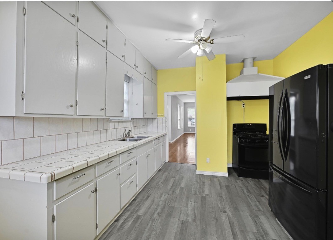 2418 Delafield Street Houston, TX 77023 - Photo 4 of 8 a kitchen with stainless steel appliances a stove refrigerator and cabinets