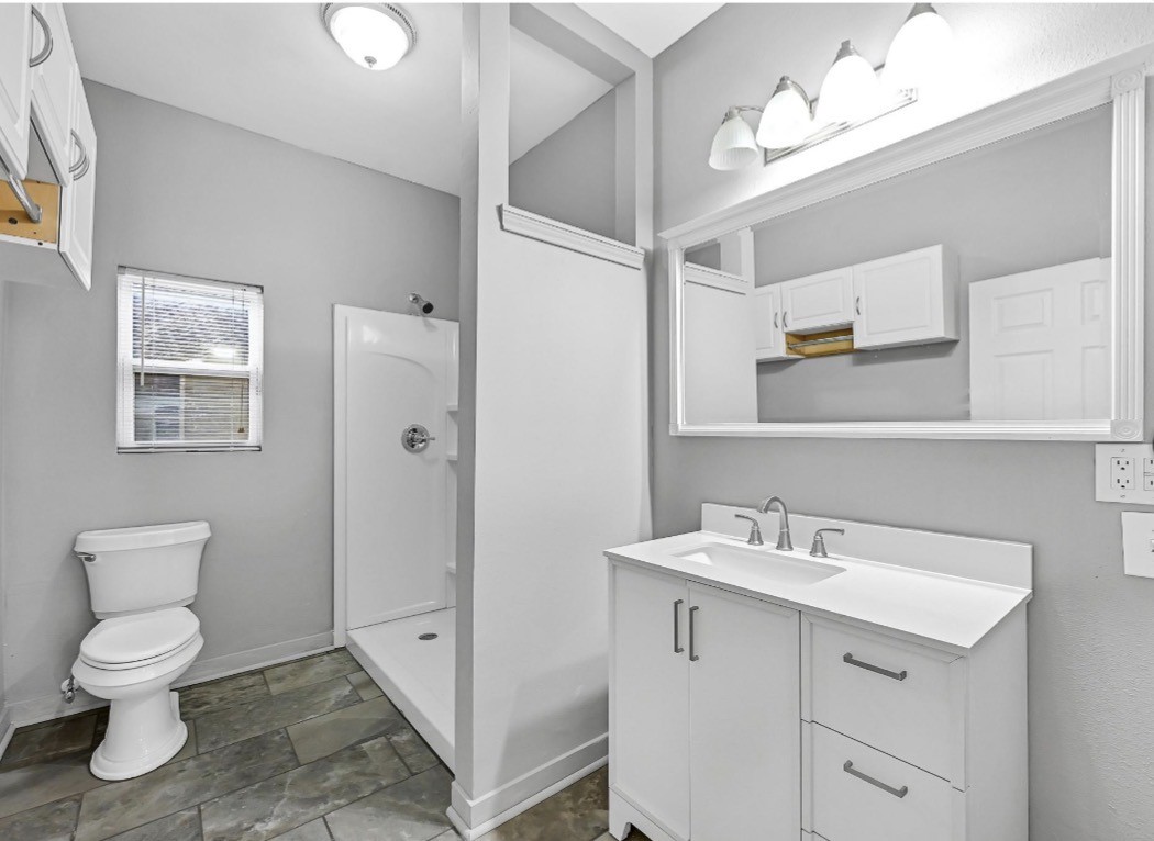 2418 Delafield Street Houston, TX 77023 - Photo 6 of 8 a bathroom with a toilet sink and mirror