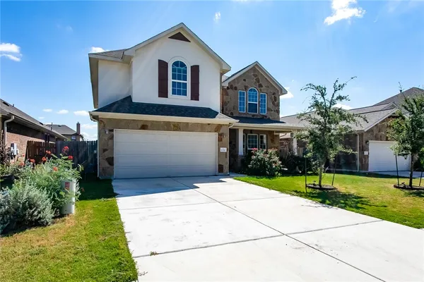 a front view of a house with a yard and garage