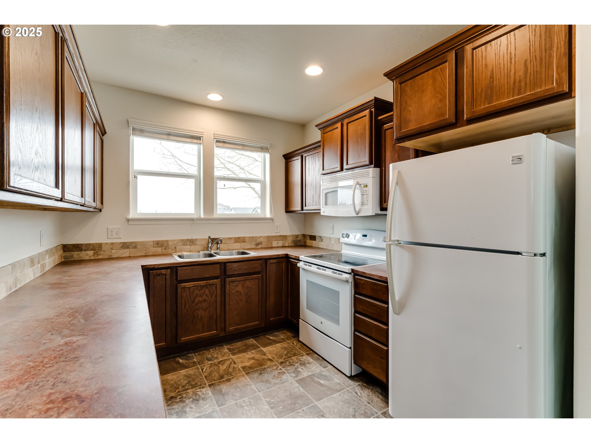 1565 Legacy Street Eugene, OR 97402 - Photo 11 of 27 a kitchen with granite countertop a refrigerator stove top oven and sink