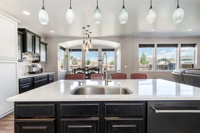 a kitchen with a sink a counter and chairs