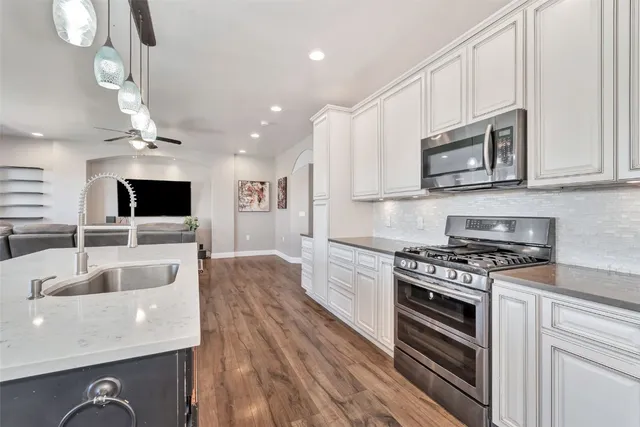 a large kitchen with stainless steel appliances granite countertop a stove a sink and a microwave