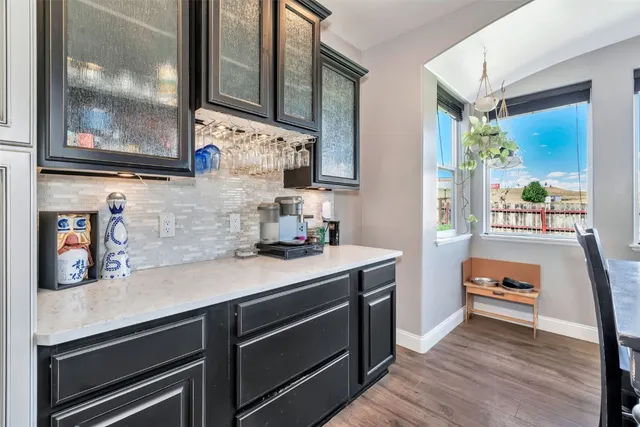 a kitchen with stainless steel appliances a sink and wooden floor