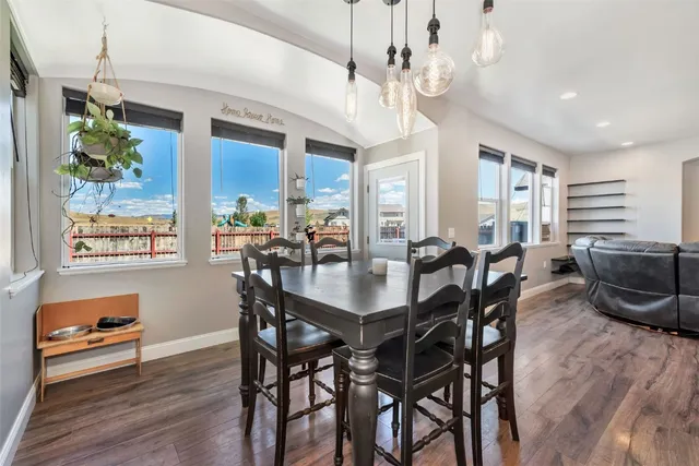 a view of a dining room with furniture a chandelier and wooden floor
