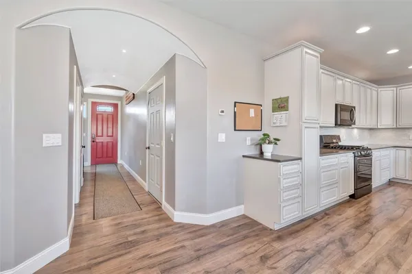 a kitchen with white cabinets and stainless steel appliances