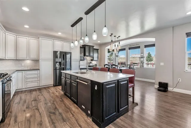 a kitchen with stainless steel appliances granite countertop a sink a stove and a refrigerator