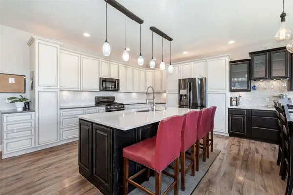a kitchen with stainless steel appliances kitchen island granite countertop a sink refrigerator and microwave