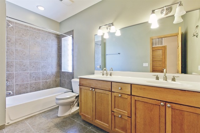 2828 South Lock Street Chicago, IL 60608 - Photo 17 of 21 a bathroom with a double vanity sink a toilet a mirror and bathtub
