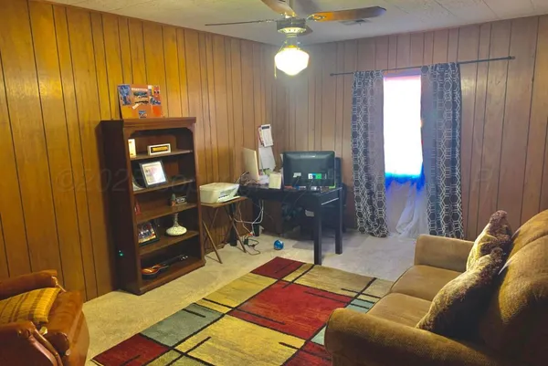a living room with furniture a lamp and a bookshelf