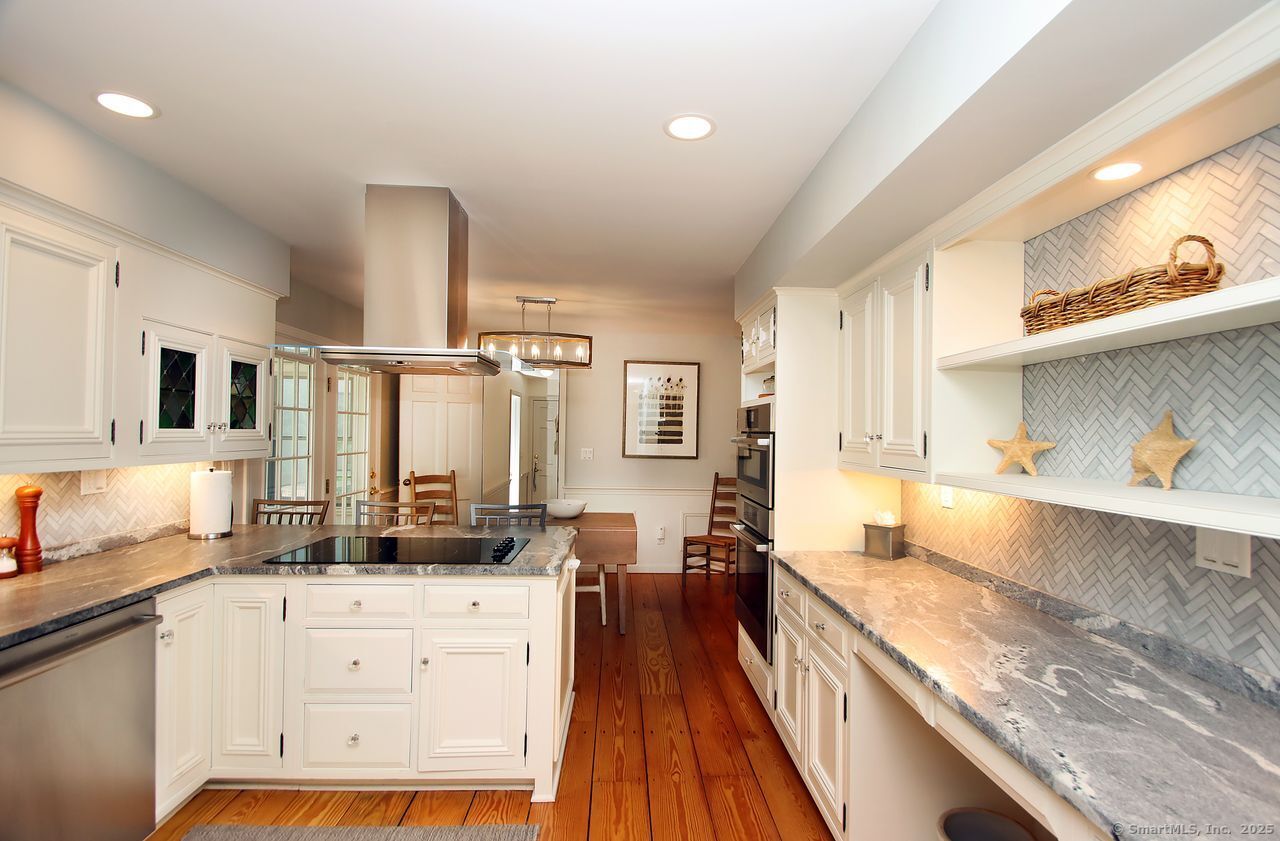 125 Wildcat Road Madison, CT 06443 - Photo 13 of 34 a kitchen with stainless steel appliances granite countertop a lot of counter space and wooden floors