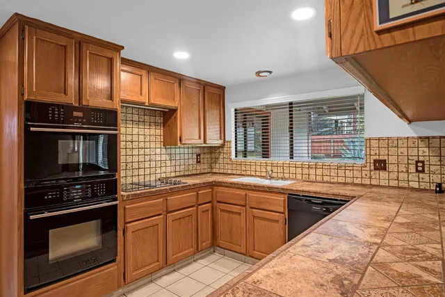 a kitchen with stainless steel appliances a stove sink and cabinets