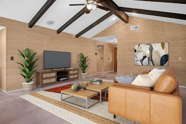 a living room with furniture a flat screen tv and a potted plant