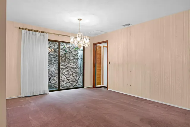 an empty room with closet and chandelier fan