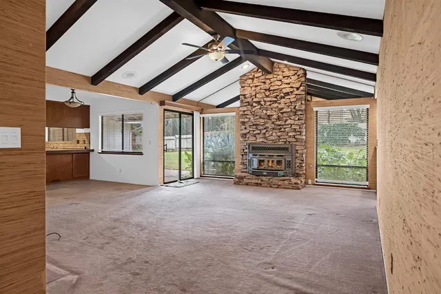 a view of an empty room with a fireplace and a window