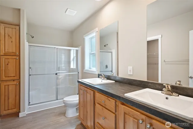 a bathroom with a sink a toilet and shower