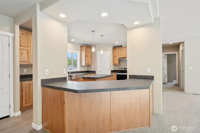 a kitchen with kitchen island a sink appliances and a counter top space
