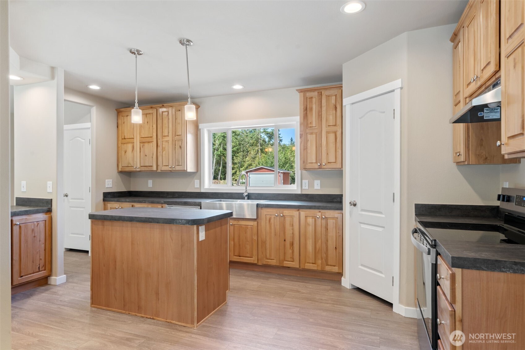 73 Butterfly Lane Sequim, WA 98382 - Photo 6 of 34 a kitchen with stainless steel appliances granite countertop a stove a sink a refrigerator and white cabinets with wooden floor