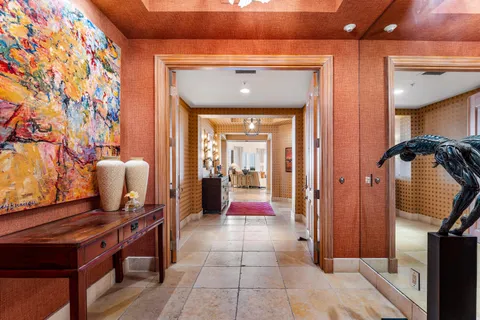 a view of a hallway with a elevator and chandelier