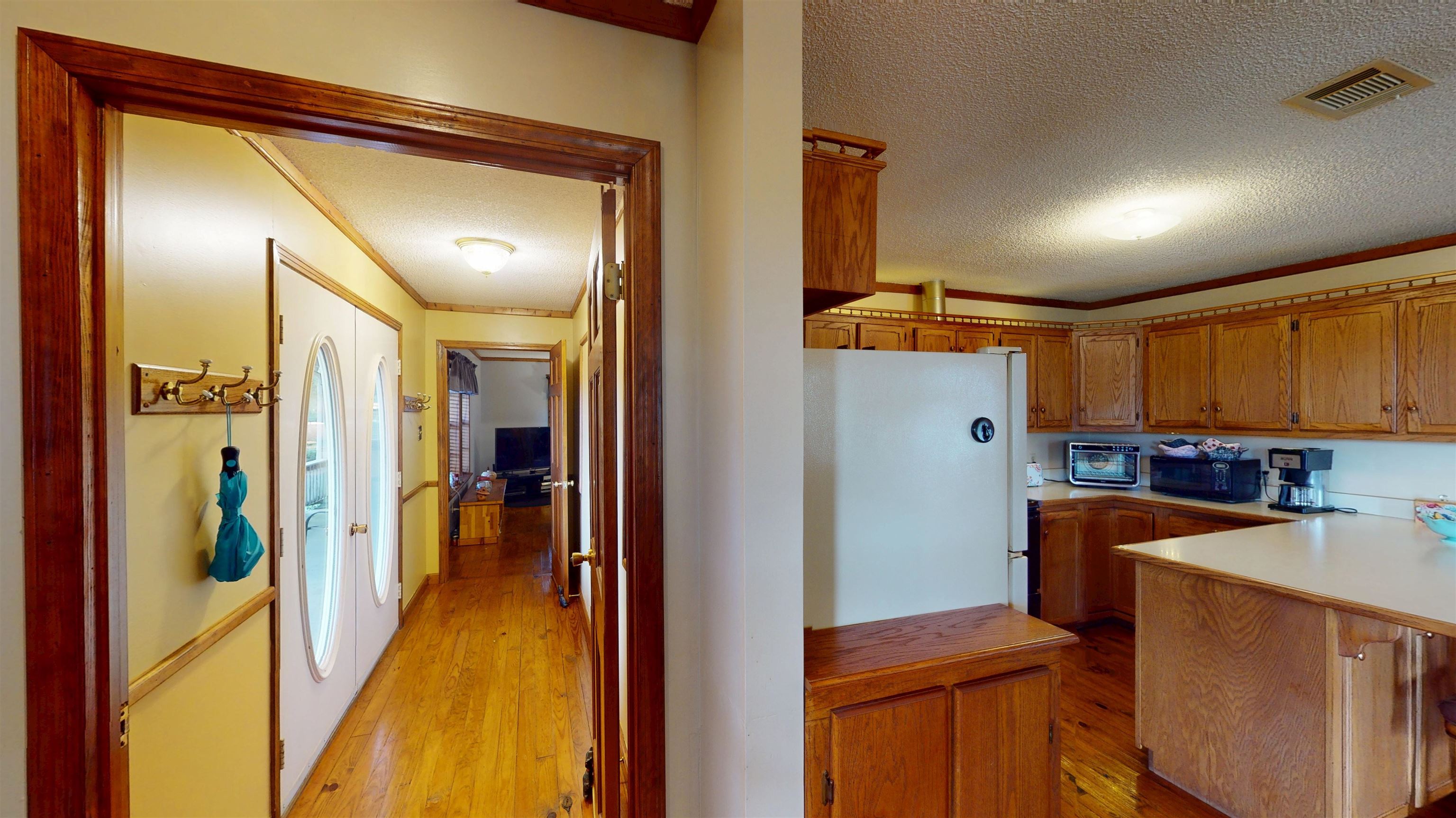 420 Joann Road Somerville, TN 38068 - Photo 14 of 40 Hardwood flooring throughout, double entry doors with oval glass inserts, wood-finish cabinetry, and solid surface countertops