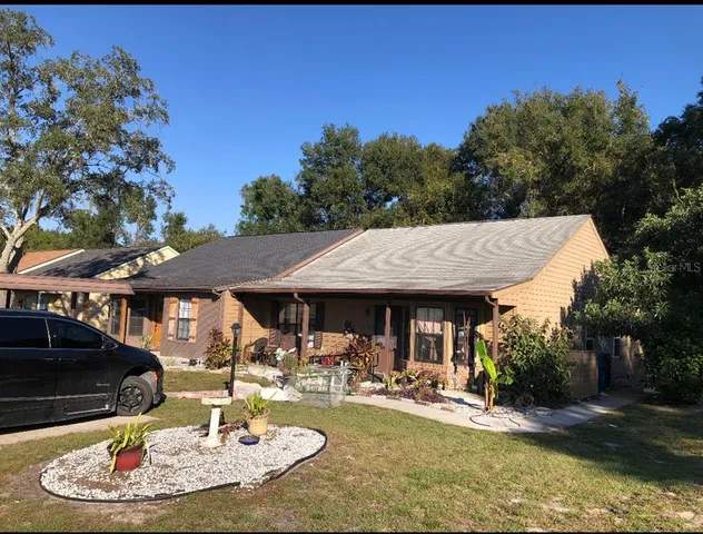 a view of a house with backyard water fountain and sitting area