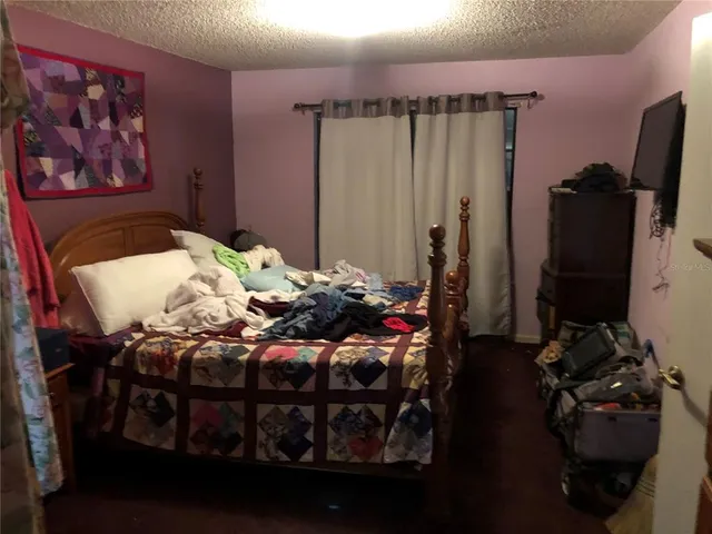 a bedroom with a bed and a flat tv screen