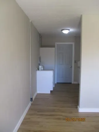 a view of a room with wooden floor