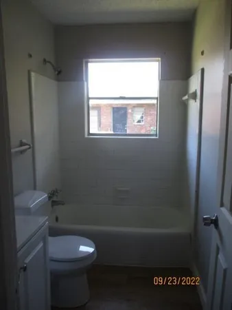 a bathroom with a toilet a sink and a window