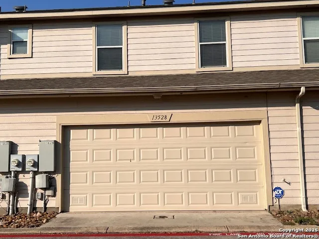 an empty room with wooden floor chandelier fan and windows