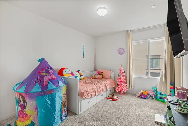 a bedroom with baby bed toys and a potted plant on the dresser