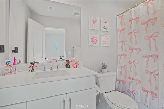 a bathroom with a sink vanity mirror and toilet