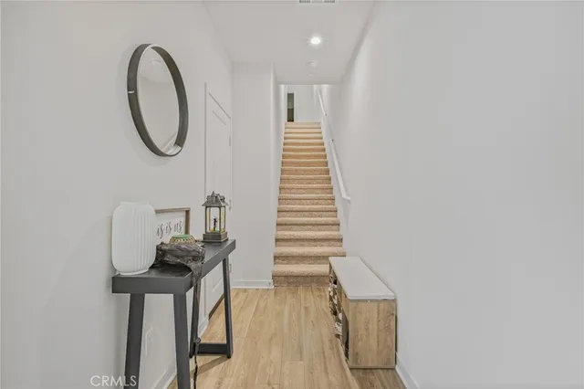 a view of entryway and hall with wooden floor