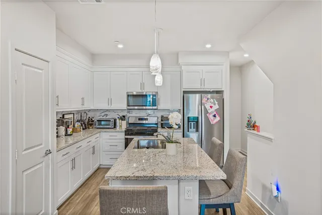 a kitchen with white cabinets and sink