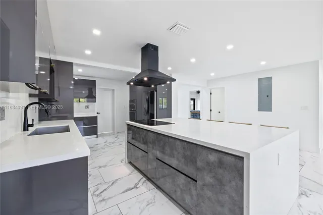 a kitchen with stainless steel appliances kitchen island granite countertop a refrigerator and a sink