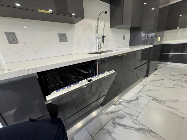 a living room with furniture kitchen view and a chandelier