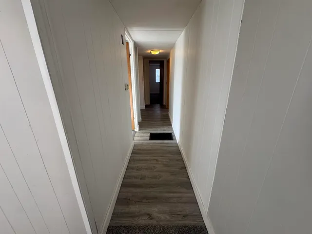 a view of a hallway with wooden floor and entryway