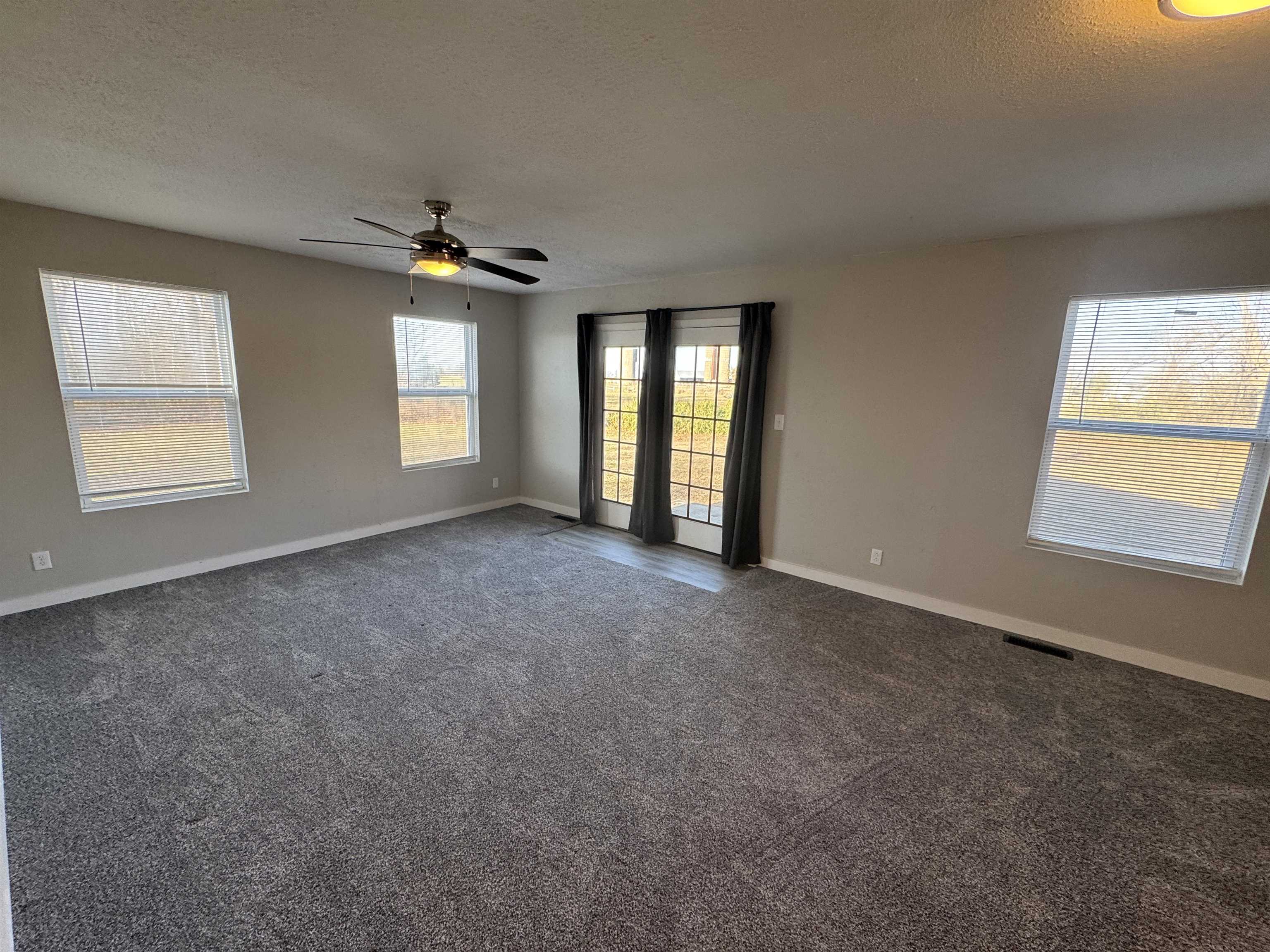 409 West 9th Street Sandoval, IL 62882 - Photo 21 of 31 an empty room with windows and ceiling fan