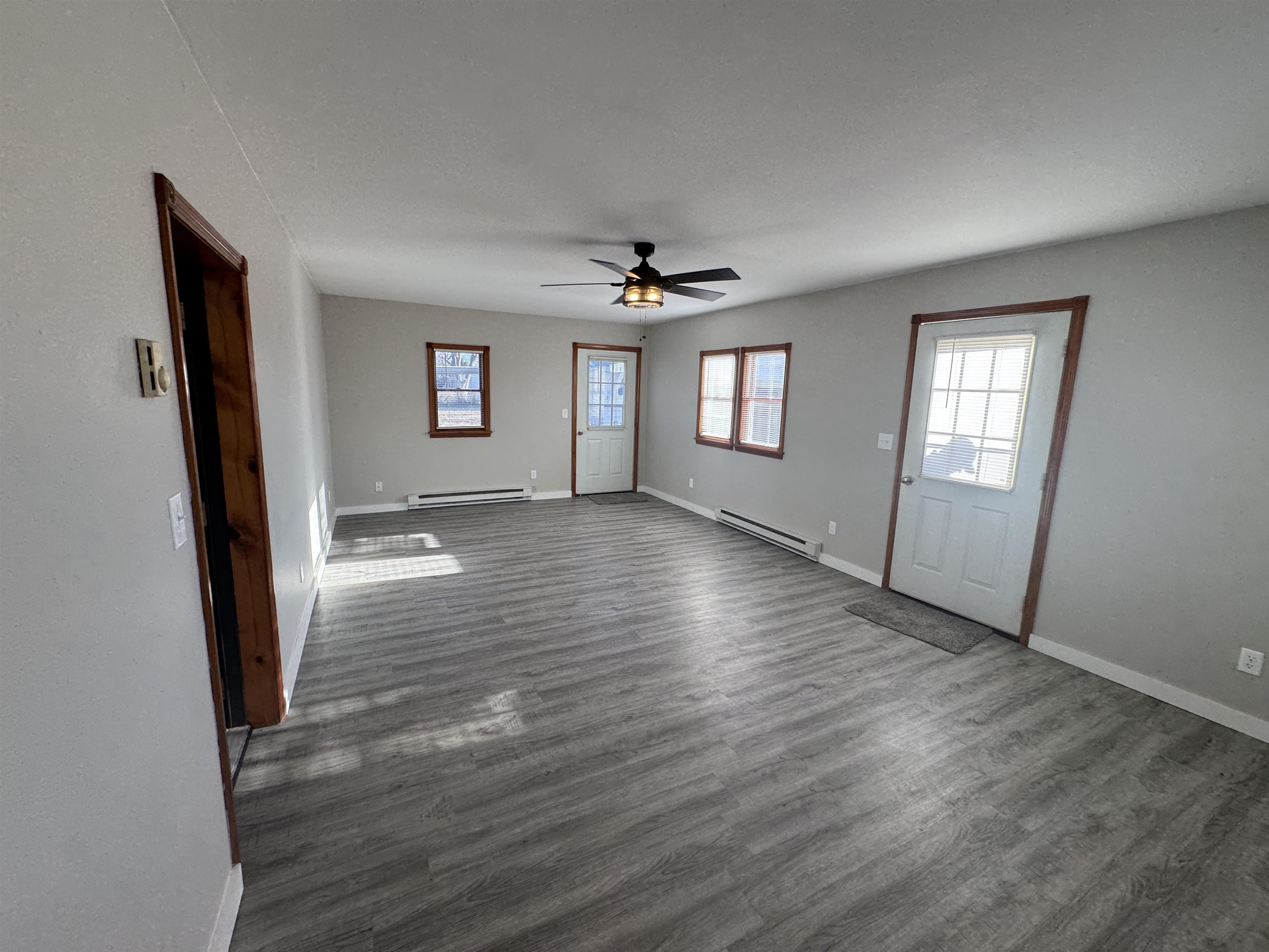 409 West 9th Street Sandoval, IL 62882 - Photo 5 of 31 an empty room with wooden floor and windows