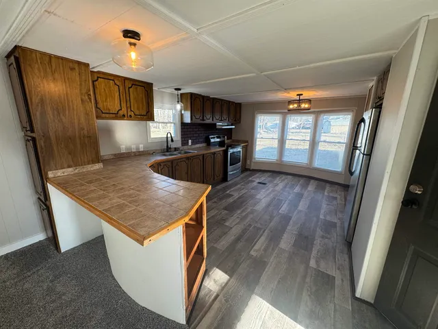 a kitchen with a wooden floor and electric appliances