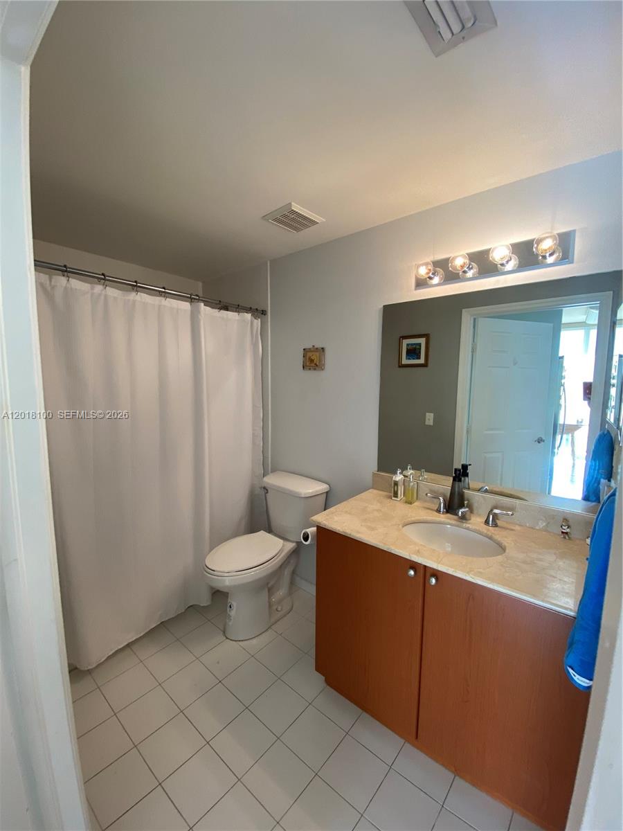 2425 Southwest 27th Avenue, Unit 1008 Miami, FL 33145 - Photo 17 of 20 a bathroom with a sink a toilet and mirror