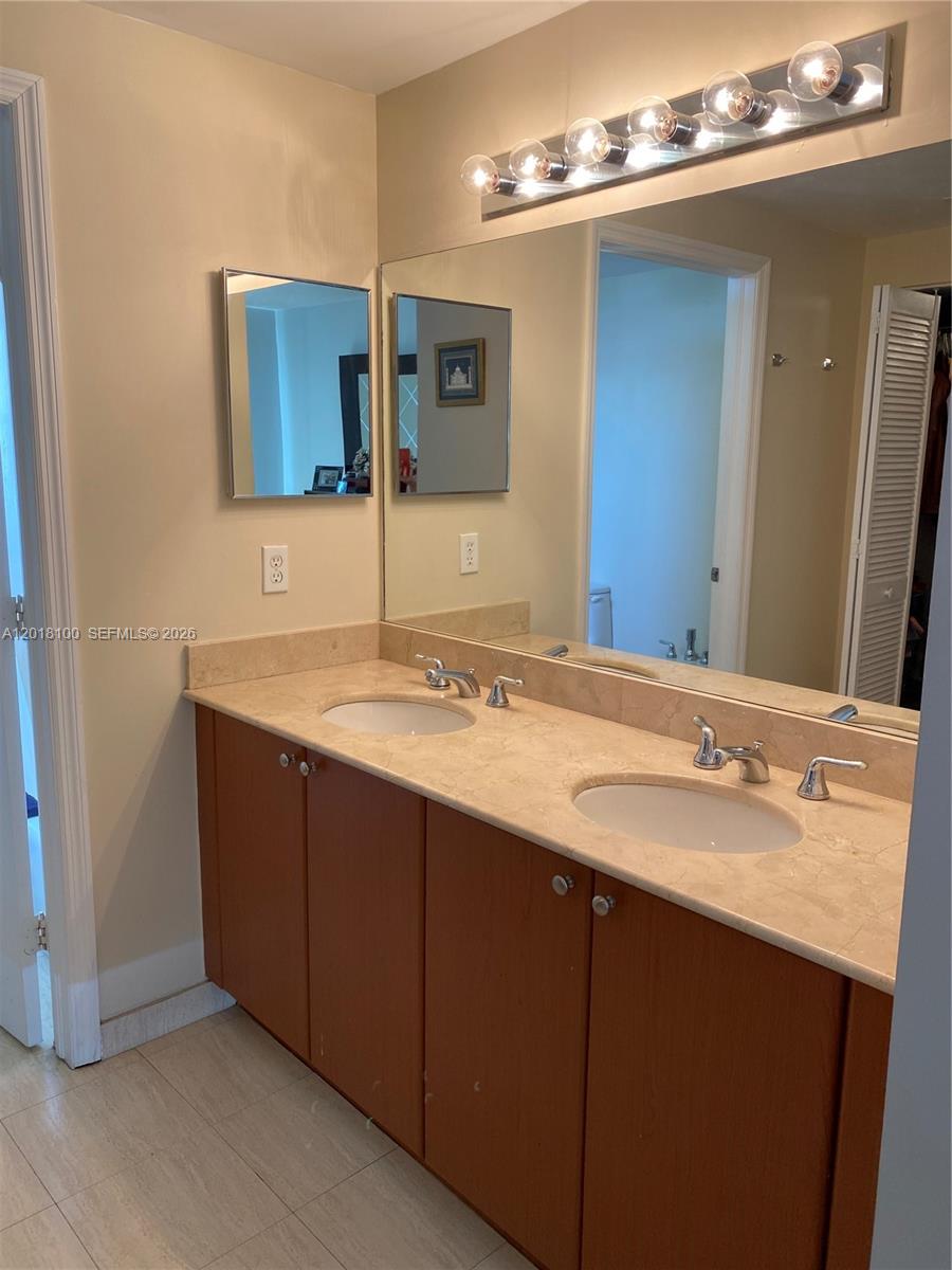 2425 Southwest 27th Avenue, Unit 1008 Miami, FL 33145 - Photo 18 of 20 a bathroom with a double vanity sink and a mirror