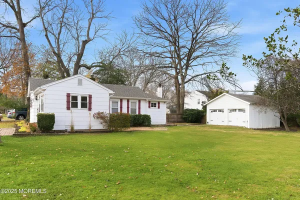 a front view of a house with a yard and trees