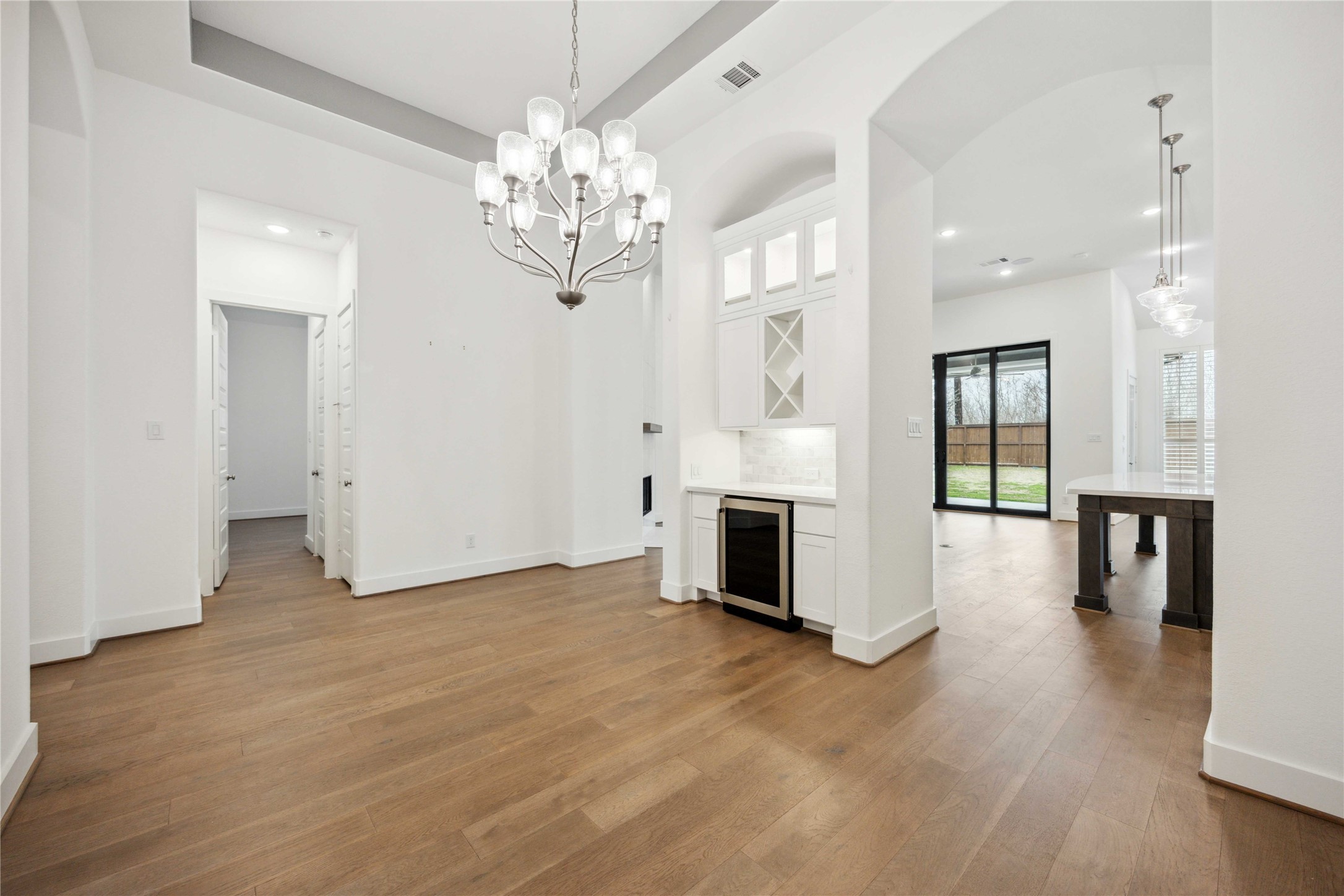 2711 Merlin Way Katy, TX 77493 - Photo 23 of 50 View of formal dining room with wine fridge. Kitchen and hall to secondary bedrooms in the background.