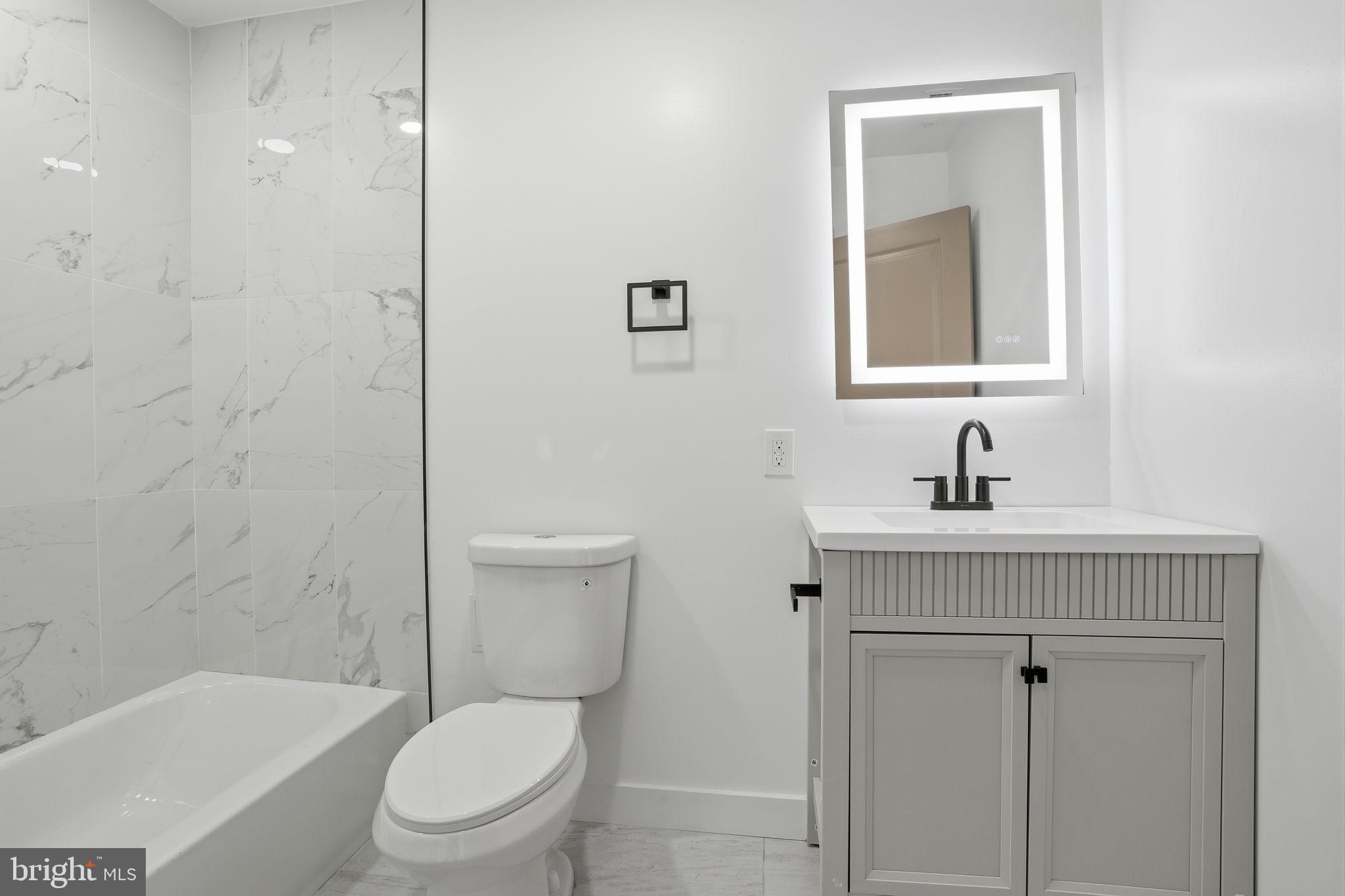 14 Inlet Road Levittown, PA 19057 - Photo 5 of 31 a bathroom with a toilet a sink a bath tub and a mirror