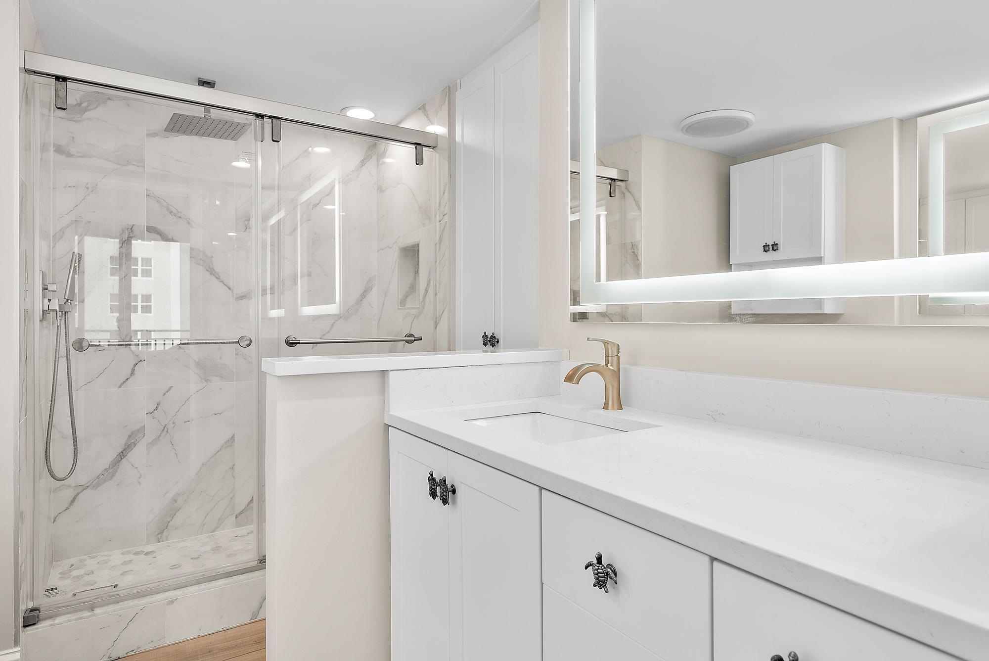 5460 North Ocean Drive, Unit 3B Riviera Beach, FL 33404 - Photo 16 of 26 a bathroom with a sink vanity granite tub shower and a mirror