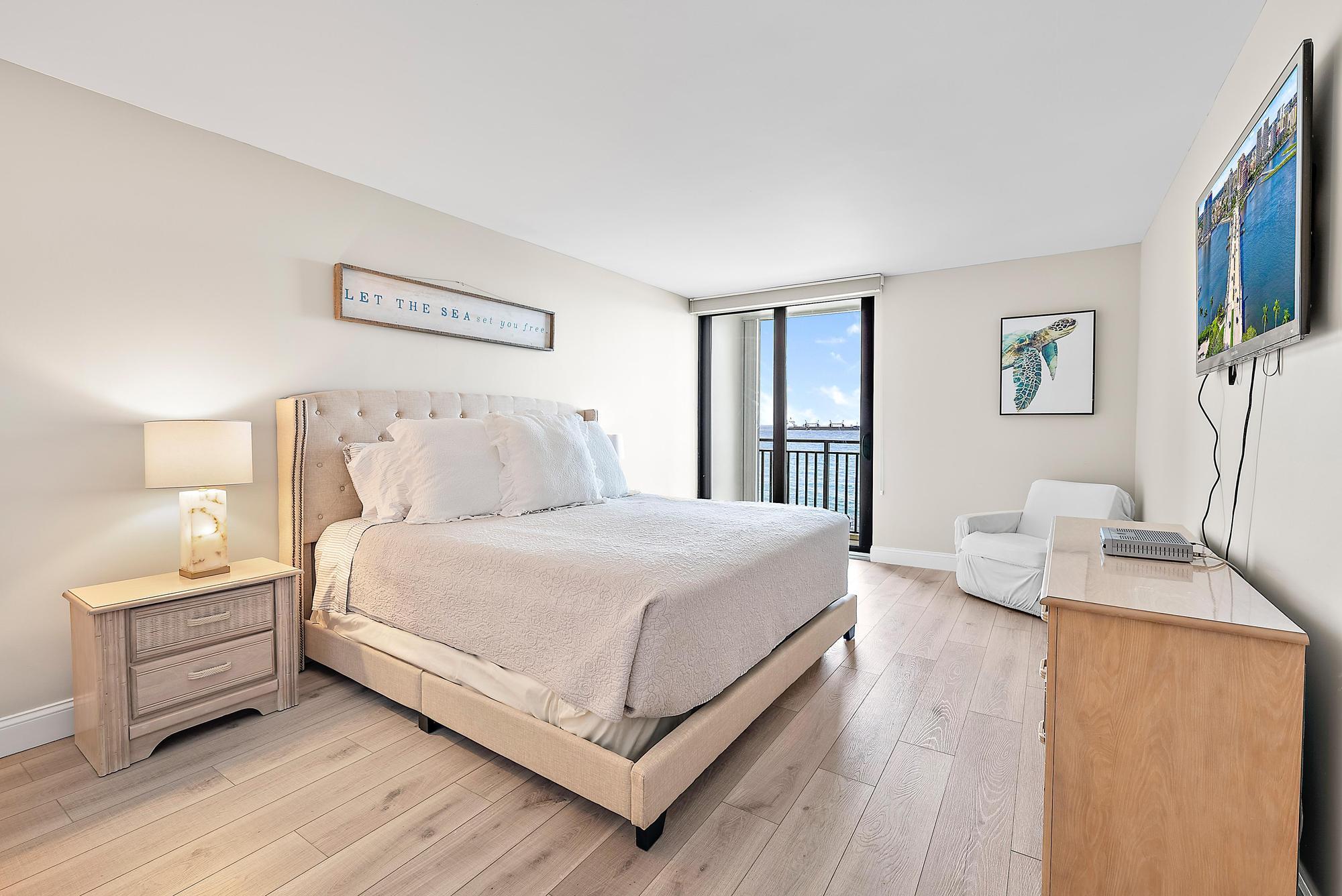5460 North Ocean Drive, Unit 3B Riviera Beach, FL 33404 - Photo 18 of 26 a bedroom with a bed and a flat screen tv