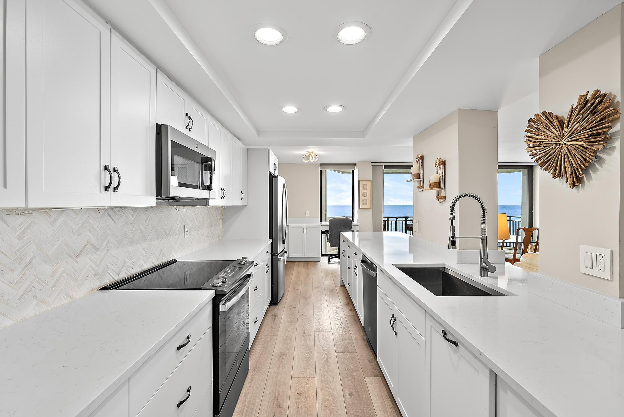 5460 North Ocean Drive, Unit 3B Riviera Beach, FL 33404 - Photo 4 of 26 a large kitchen with stainless steel appliances granite countertop a lot of counter space and wooden floors