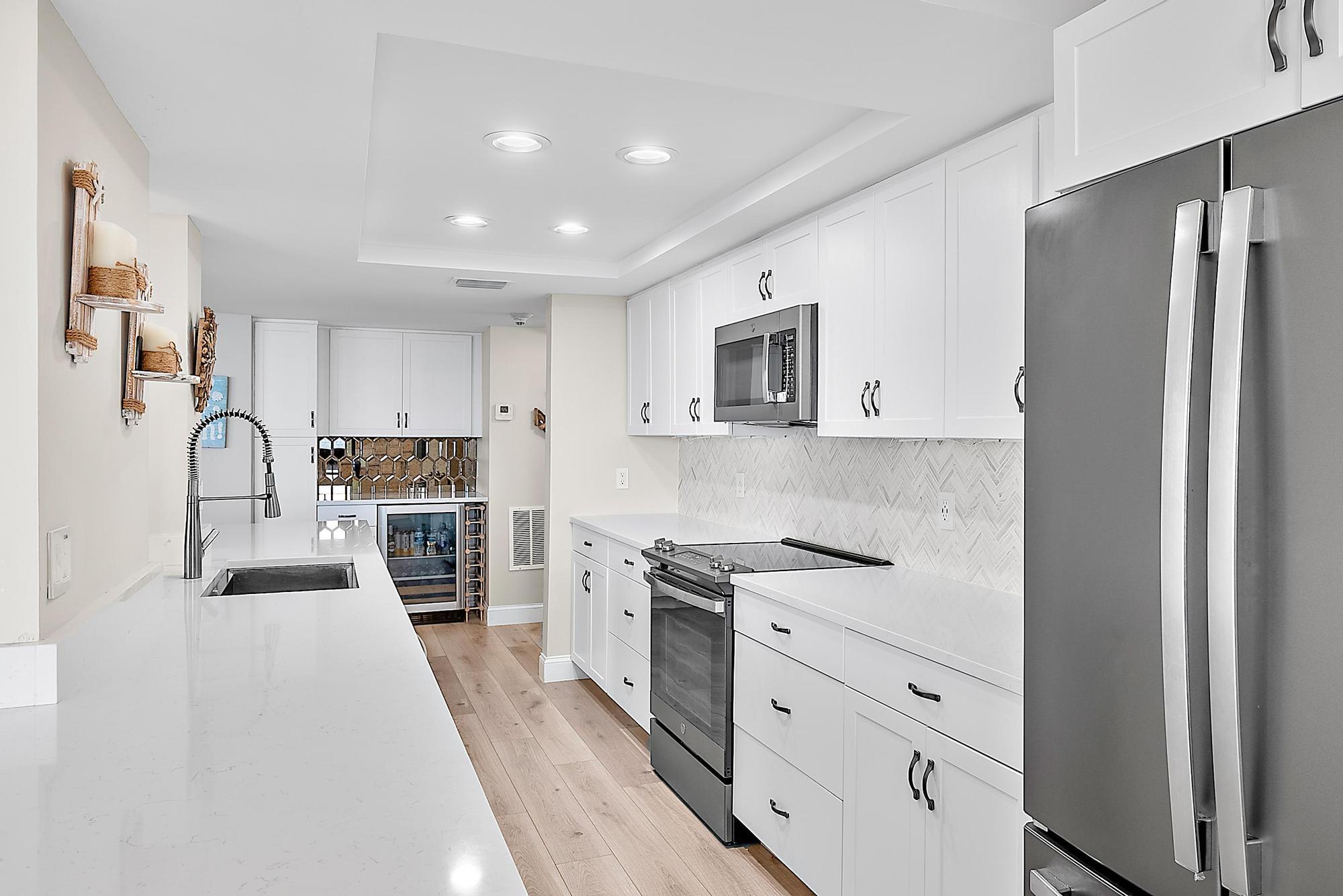 5460 North Ocean Drive, Unit 3B Riviera Beach, FL 33404 - Photo 5 of 26 a kitchen with granite countertop a refrigerator stove top oven and sink